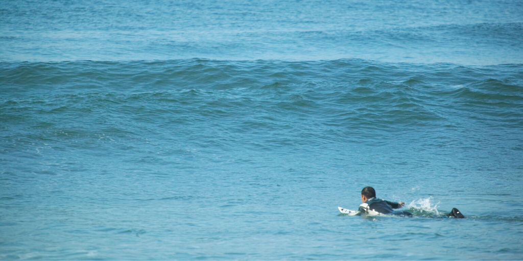 Welle anpaddeln beim Surfen 